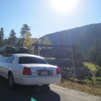 Stagecoach large white stretch limo with cargo boxes parked next to keystone Colorado Ski resort sign