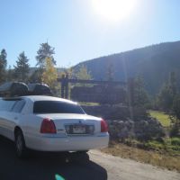 Stagecoach large white stretch limo with cargo boxes parked next to keystone Colorado Ski resort sign