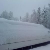 Large stretch white Stagecoach Limo covered in new snow