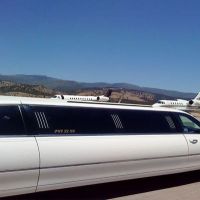 Large stretch white Stagecoach Limo at private airport